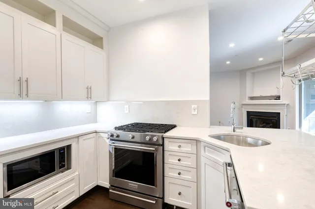a kitchen with granite countertop white cabinets and white appliances