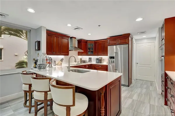 a kitchen with stainless steel appliances a table and chairs in it