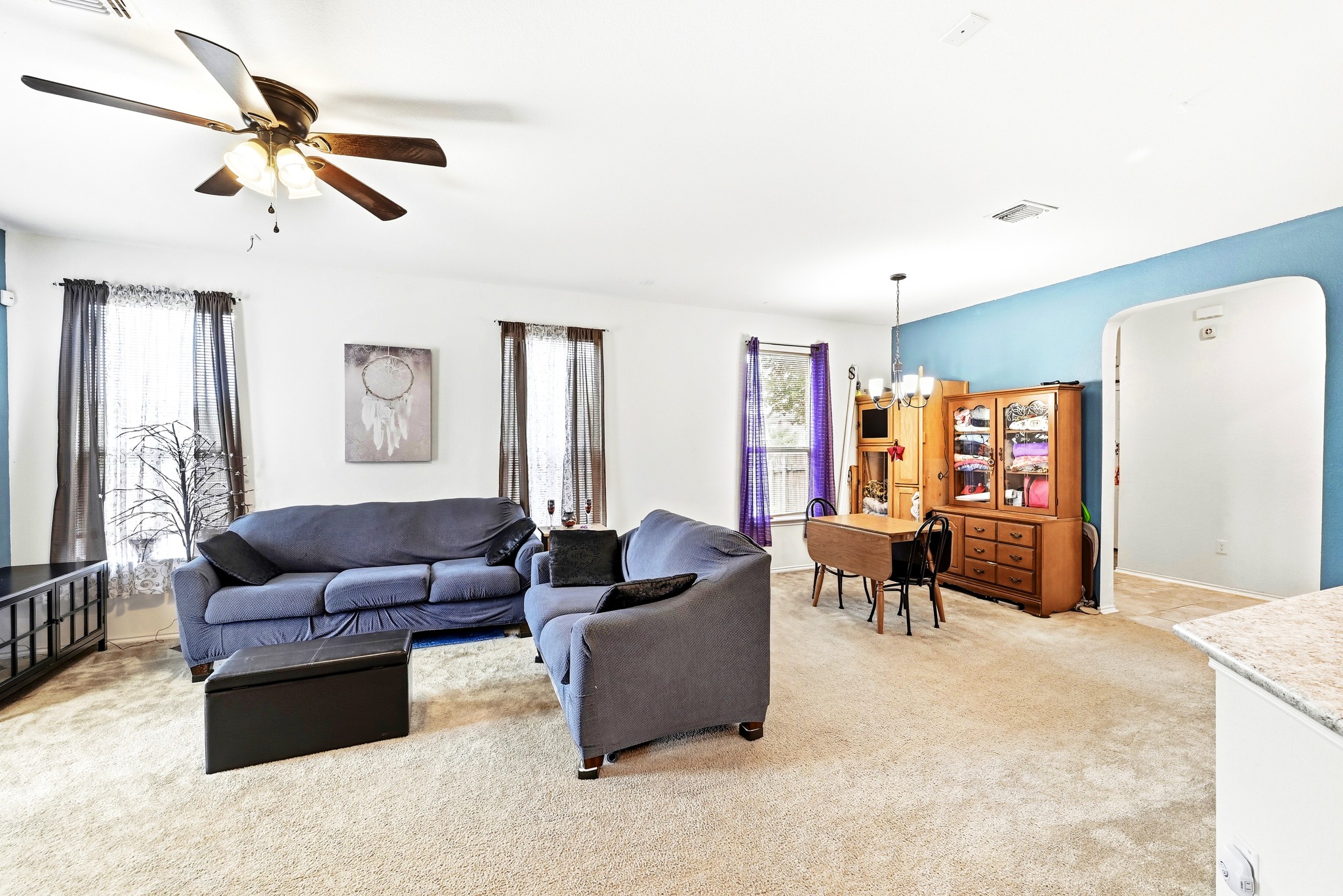 1621 Dragonfly Loop Bastrop, TX 78602 - Photo 9 of 27 Open-concept living area featuring light-colored carpet flooring and a ceiling fan with integrated lighting