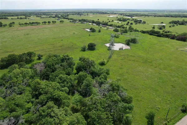 an aerial view of huge green field with lots of green space