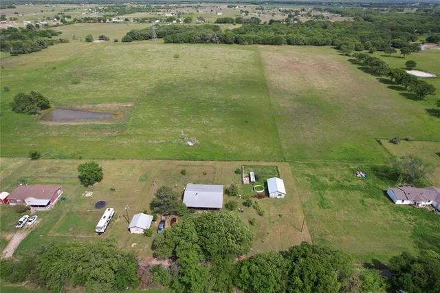 an aerial view of residential houses with outdoor space and lake view