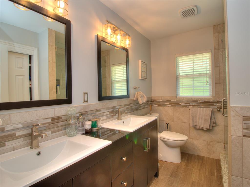 2313 Southeast 7th Street Ocala, FL 34471 - Photo 19 of 42 a bathroom with a double vanity sink toilet and a mirror