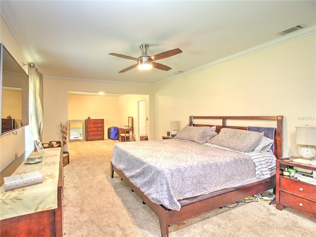 2313 Southeast 7th Street Ocala, FL 34471 - Photo 20 of 42 a bedroom with a large bed and a chandelier