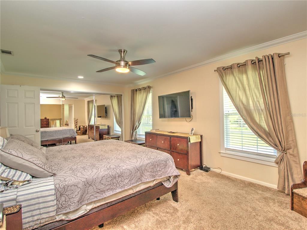 2313 Southeast 7th Street Ocala, FL 34471 - Photo 21 of 42 a bedroom with a large bed a flat screen tv and windows