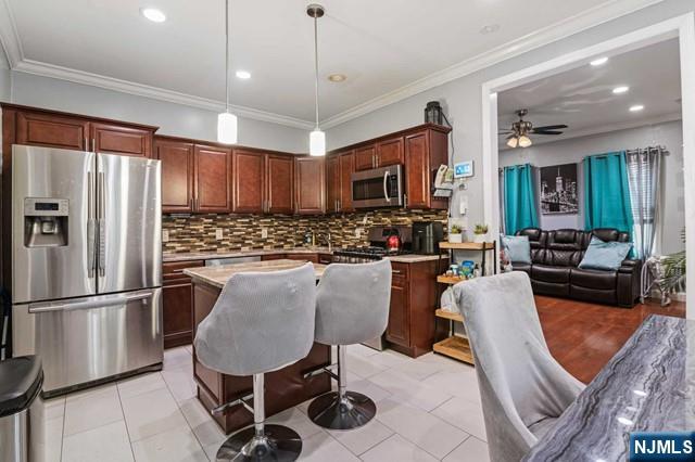 7 Martin Street Paterson, NJ 07501 - Photo 4 of 18 a kitchen with stainless steel appliances granite countertop a refrigerator a stove a sink dishwasher a dining table and chairs with wooden floor
