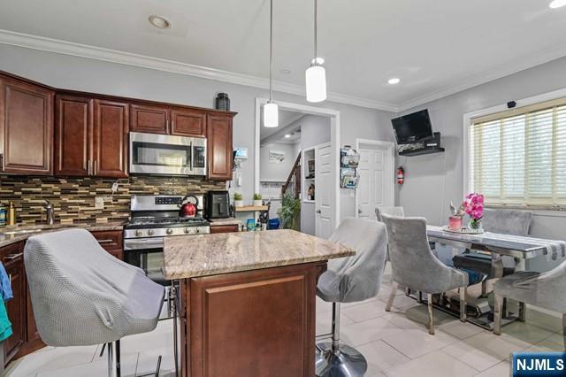 7 Martin Street Paterson, NJ 07501 - Photo 6 of 18 a kitchen with stainless steel appliances kitchen island granite countertop a refrigerator a stove top oven a sink dishwasher and white cabinets