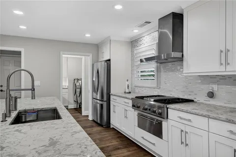 a kitchen with stainless steel appliances granite countertop a sink stove and refrigerator
