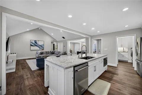 a large kitchen with sink a counter top space and stainless steel appliances