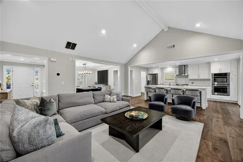 a living room with furniture and view of kitchen