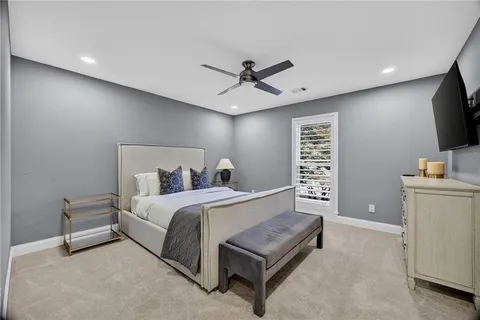 a spacious bedroom with a bed and a flat screen tv