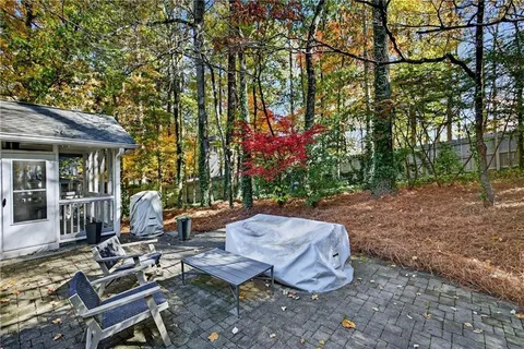 a view of a backyard with sitting area furniture and tree