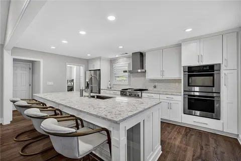 a kitchen with a sink a stove and chairs