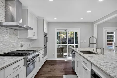 a kitchen with granite countertop a sink stove and cabinets