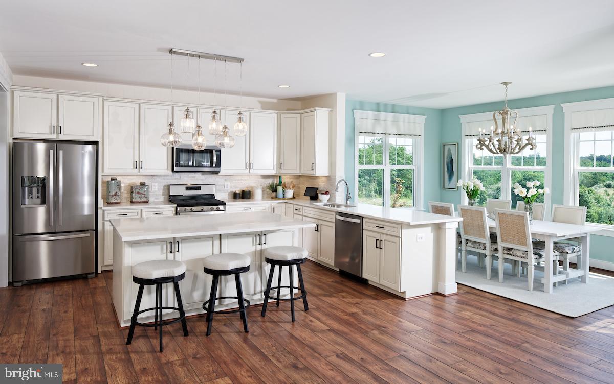 111 Interlace Way Stephenson, VA 22656 - Photo 6 of 27 a kitchen with a table chairs a sink dishwasher a refrigerator and wooden floor