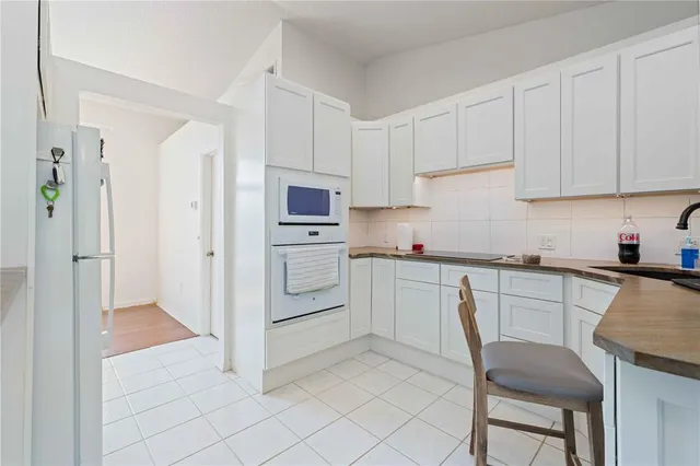 a kitchen with white cabinets and white appliances