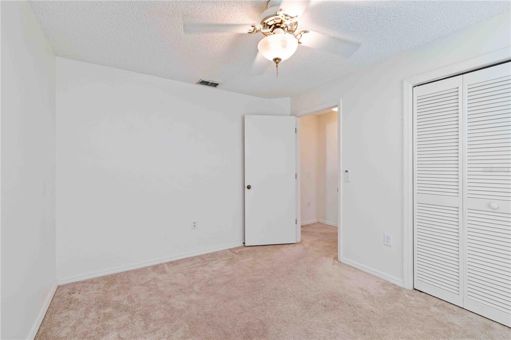 4513 Dover St Circle East Bradenton, FL 34203 - Photo 20 of 30 an empty room with a chandelier fan and windows