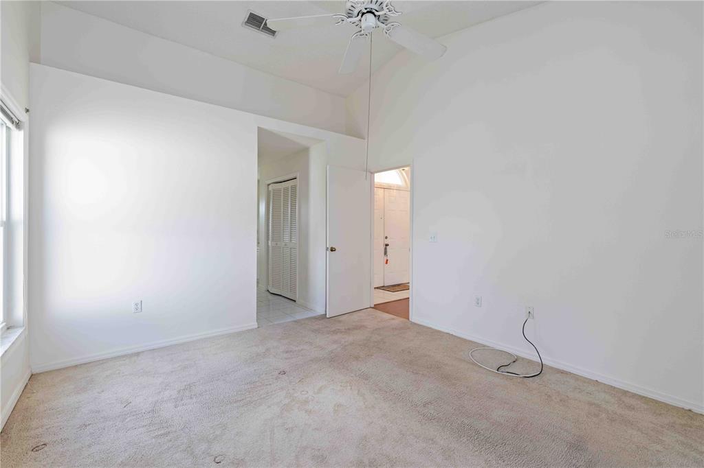 4513 Dover St Circle East Bradenton, FL 34203 - Photo 23 of 30 an empty room with a ceiling fan and carpet