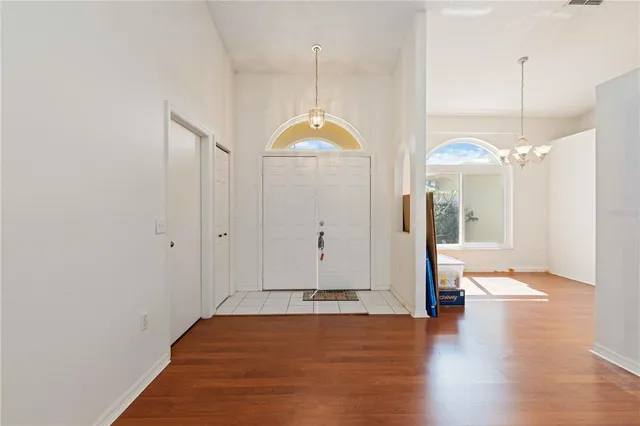 a view of a room with wooden floor and a chandelier