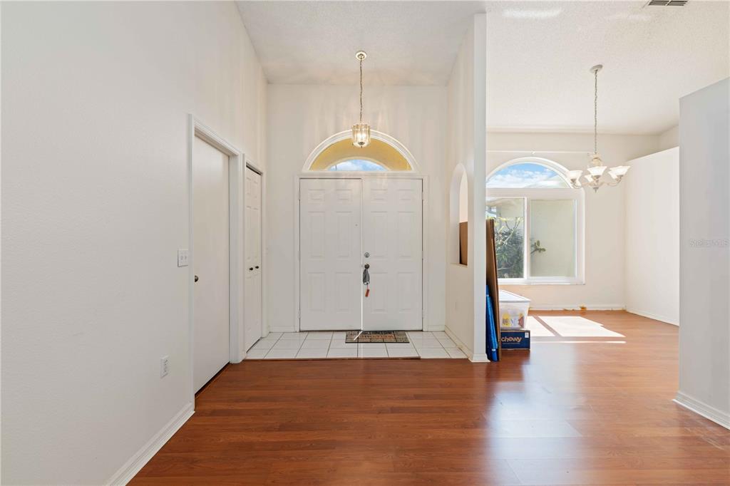 4513 Dover St Circle East Bradenton, FL 34203 - Photo 5 of 30 a view of a room with wooden floor and a chandelier