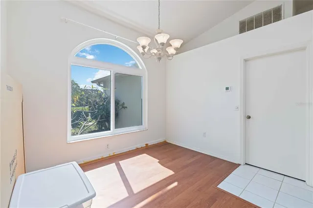 a view of a room with a chandelier fan and wooden floor