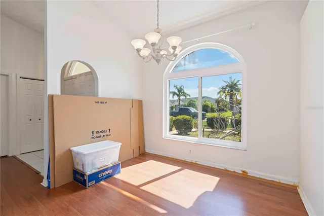a view of a bedroom with wooden floor and window