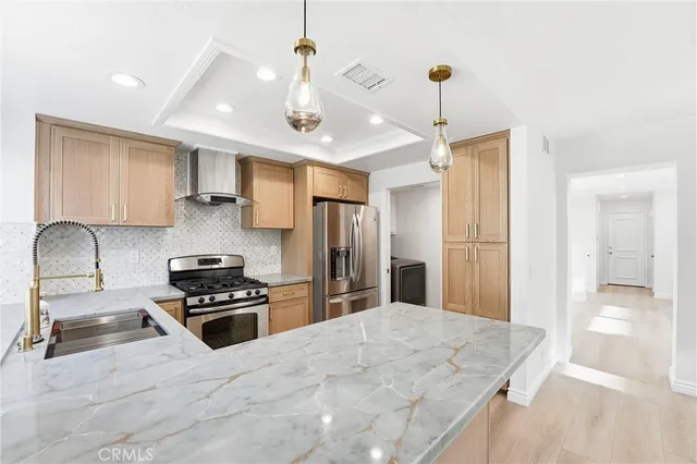 a kitchen with stainless steel appliances kitchen island granite countertop a stove and a refrigerator