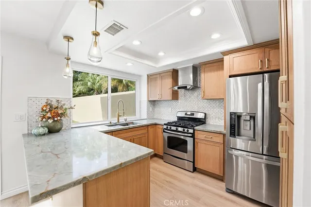 a kitchen with stainless steel appliances granite countertop a refrigerator a stove a sink dishwasher a oven with white cabinets and wooden floor