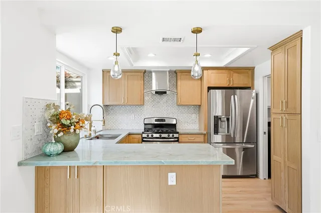 a kitchen with a refrigerator a stove a sink and dishwasher with wooden floor