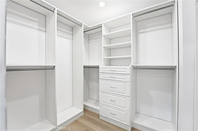 a view of walk in closet with empty racks