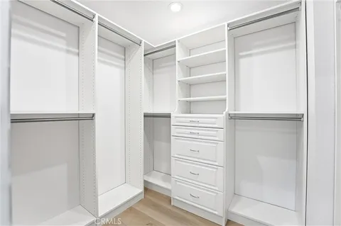 a view of walk in closet with empty racks