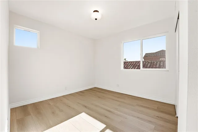 a view of a big room with wooden floor and windows
