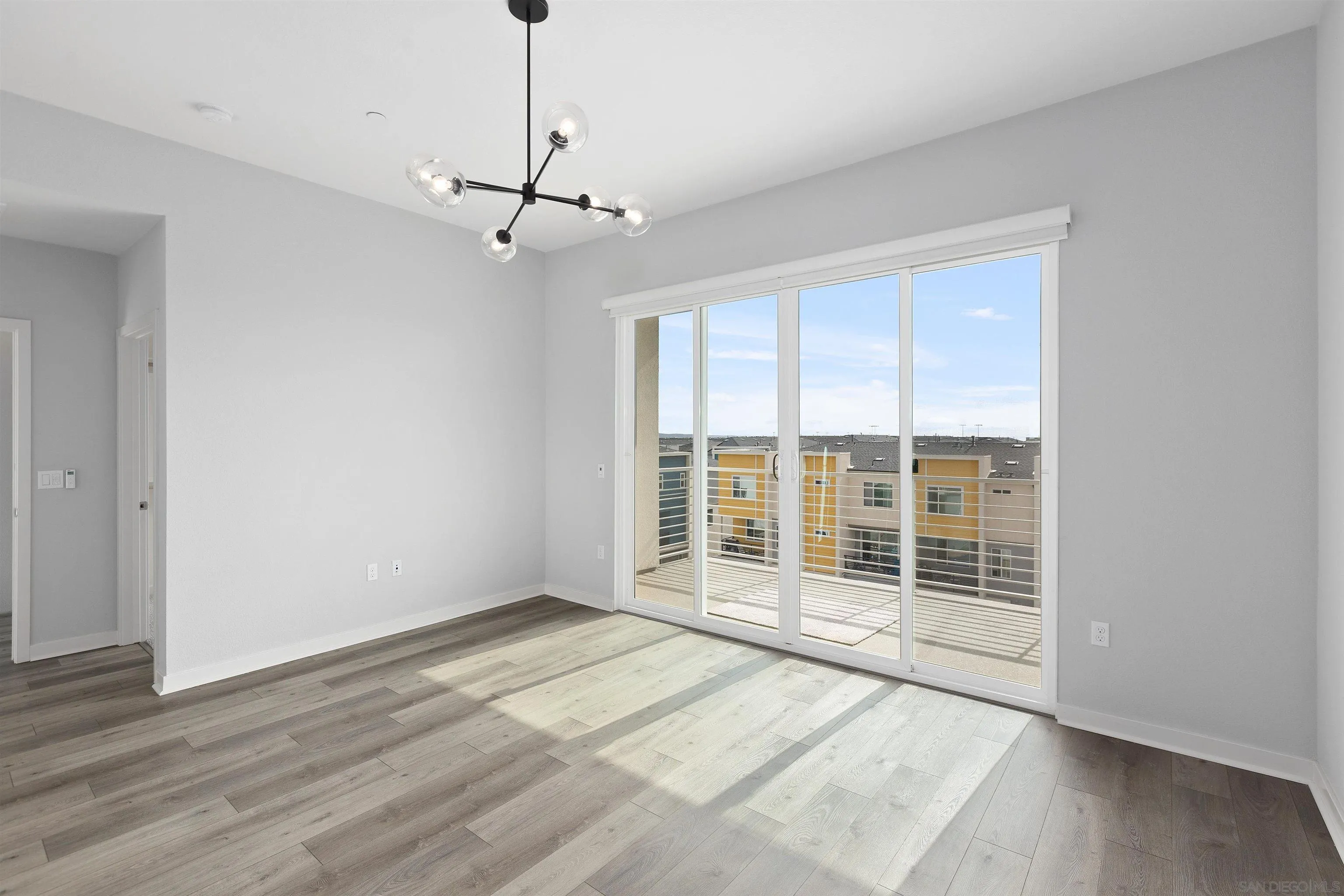 3002 Bravo Loop, Unit 4 Chula Vista, CA 91915 - Photo 17 of 36 a view of an empty room with wooden floor and a window