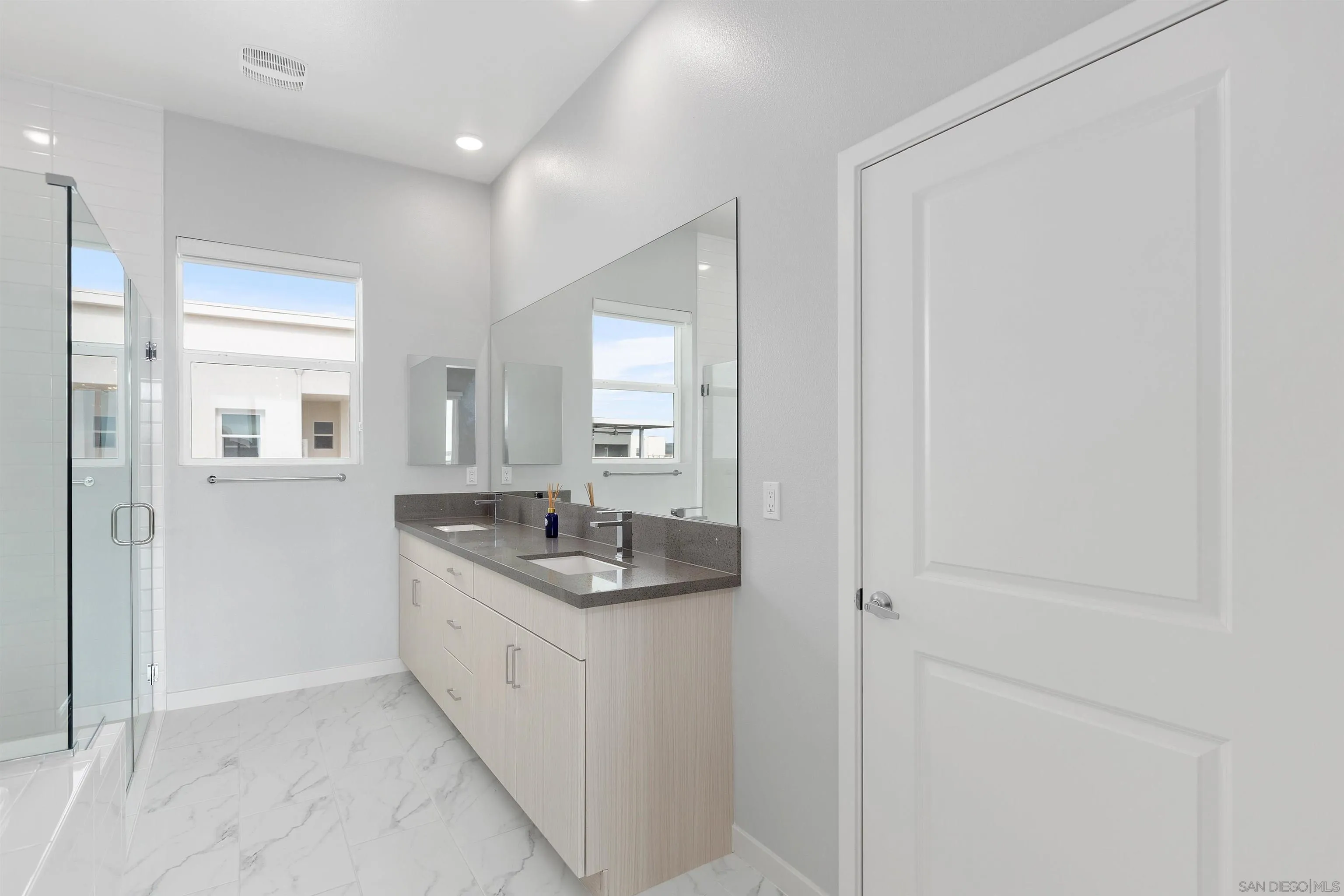 3002 Bravo Loop, Unit 4 Chula Vista, CA 91915 - Photo 26 of 36 a bathroom with a granite countertop sink and a mirror