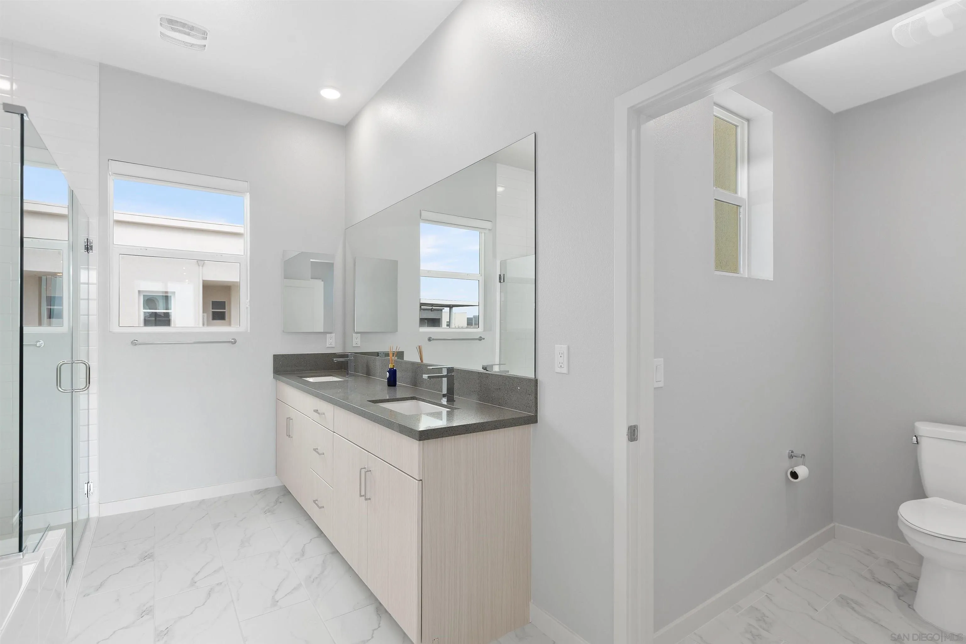 3002 Bravo Loop, Unit 4 Chula Vista, CA 91915 - Photo 27 of 36 a spacious bathroom with a granite countertop sink a toilet and a mirror