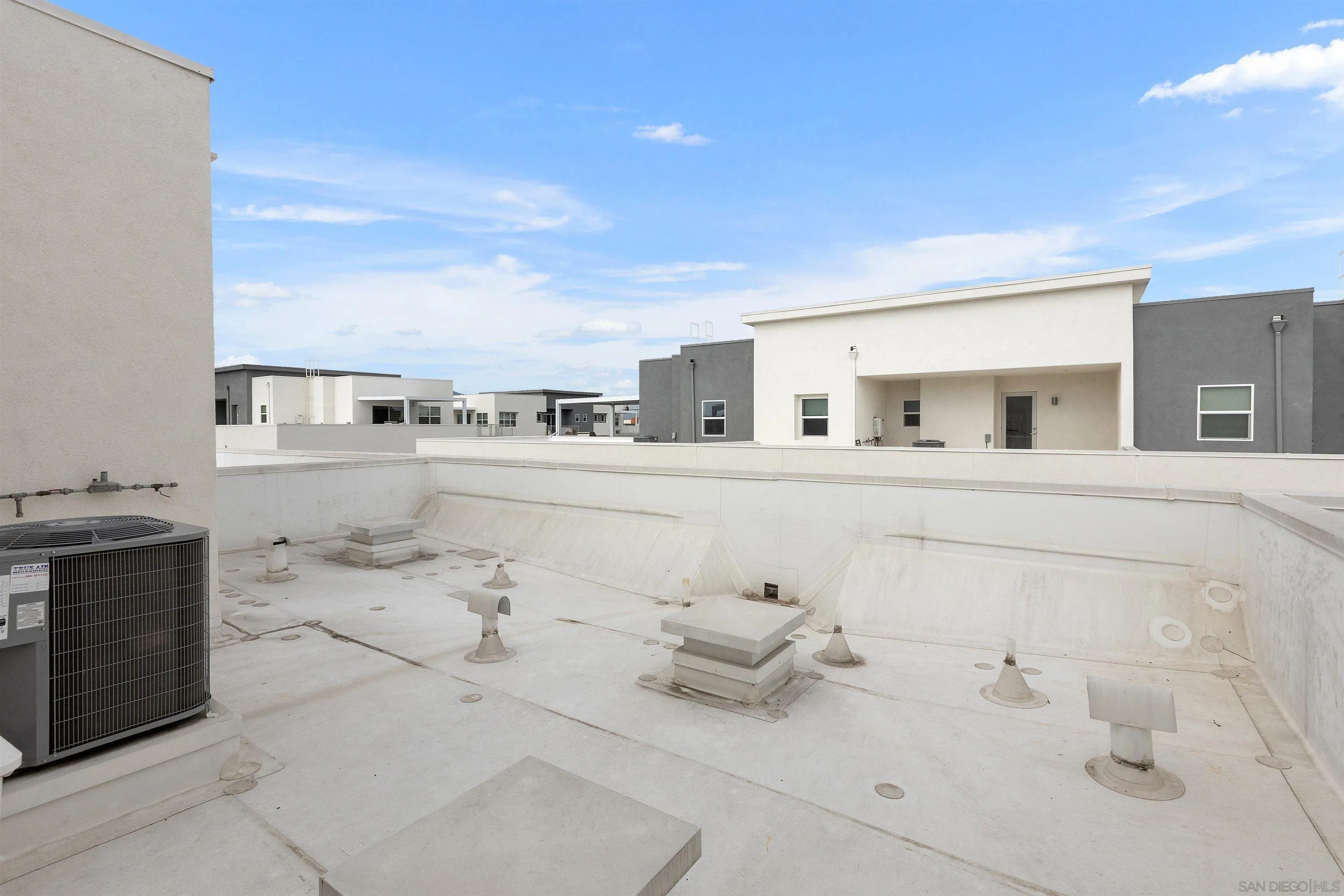 3002 Bravo Loop, Unit 4 Chula Vista, CA 91915 - Photo 35 of 36 a large white kitchen with stainless steel appliances kitchen island granite countertop a sink and cabinets