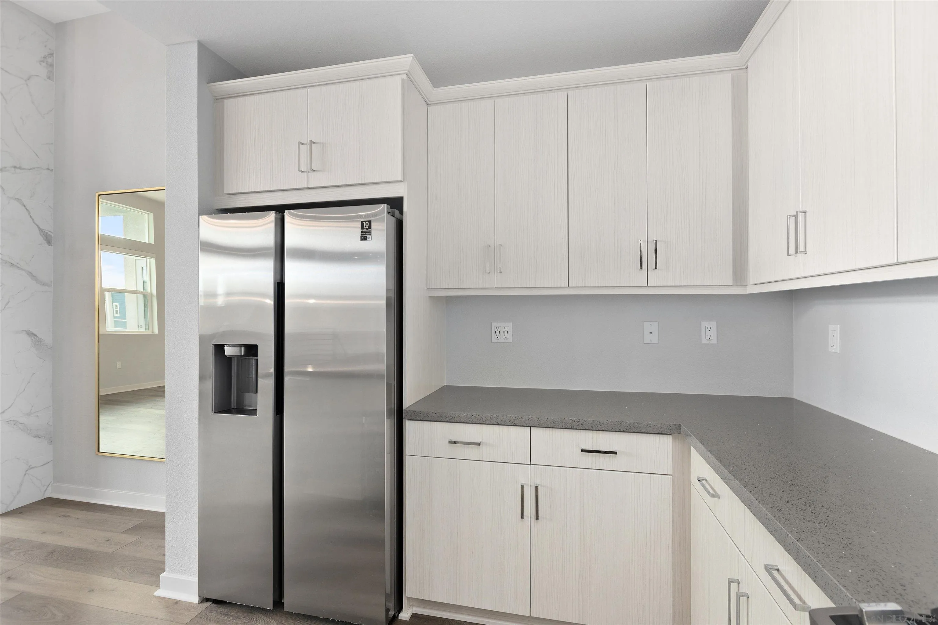 3002 Bravo Loop, Unit 4 Chula Vista, CA 91915 - Photo 9 of 36 a kitchen with stainless steel appliances white cabinets and a refrigerator