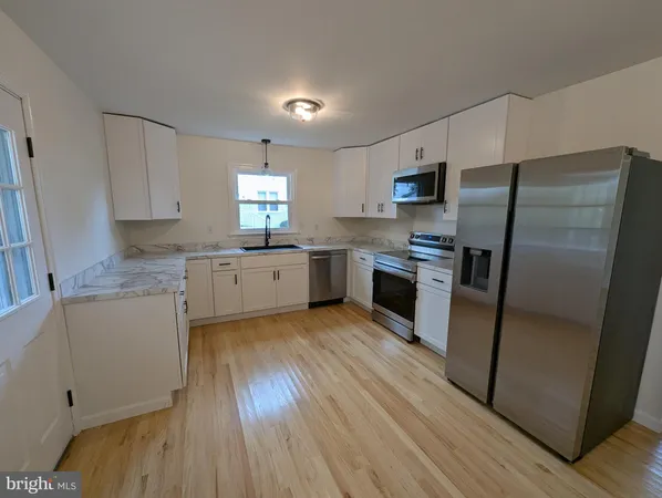 a kitchen with granite countertop a refrigerator stove top oven and sink