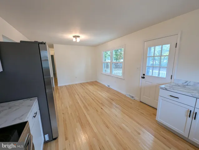 a view of a kitchen cabinets a sink and dishwasher wooden floor a fireplace