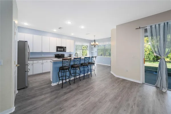 a kitchen with stainless steel appliances granite countertop wooden floors a refrigerator and a sink