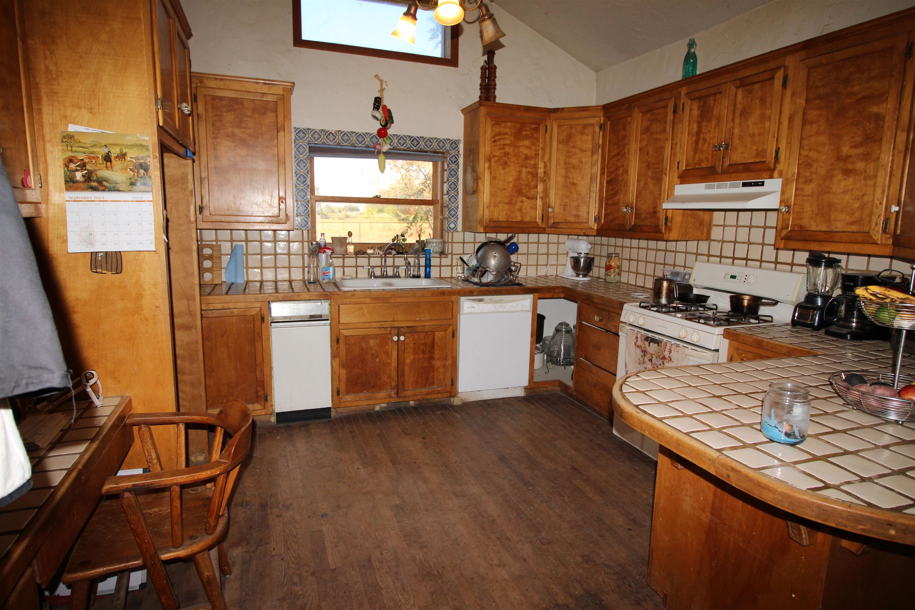 1873 K Road Fruita, CO 81521 - Photo 4 of 26 a kitchen with stainless steel appliances granite countertop wooden cabinets a sink dishwasher a stove and a refrigerator with wooden floor