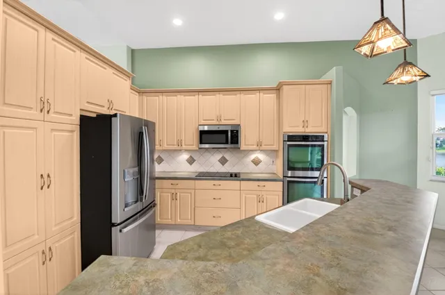 a view of a kitchen with granite countertop white cabinets and stainless steel appliances