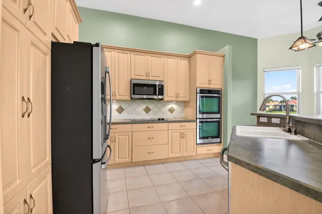 a kitchen with stainless steel appliances granite countertop a refrigerator and a stove top oven