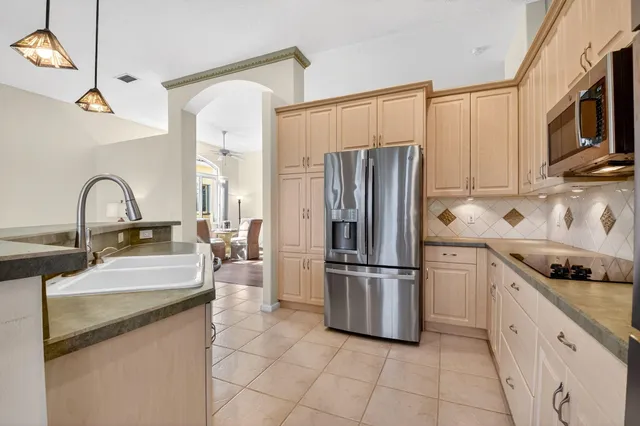 a kitchen with stainless steel appliances granite countertop a refrigerator and a stove top oven
