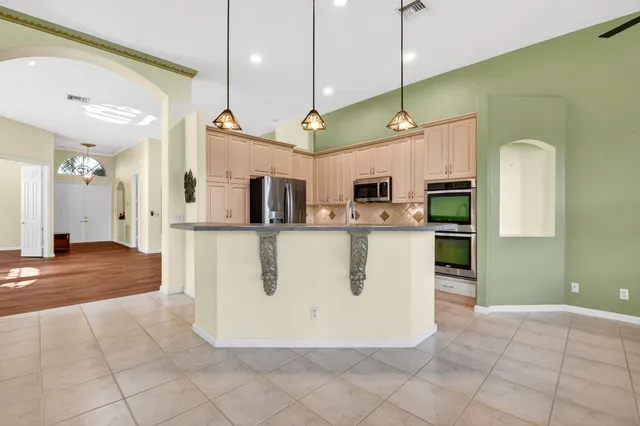 a kitchen with a stove a sink a window and a counter top space