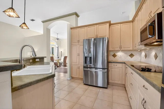 a kitchen with refrigerator and white cabinets