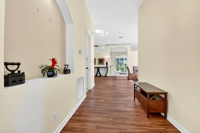 a view of a hallway with wooden floor and furniture