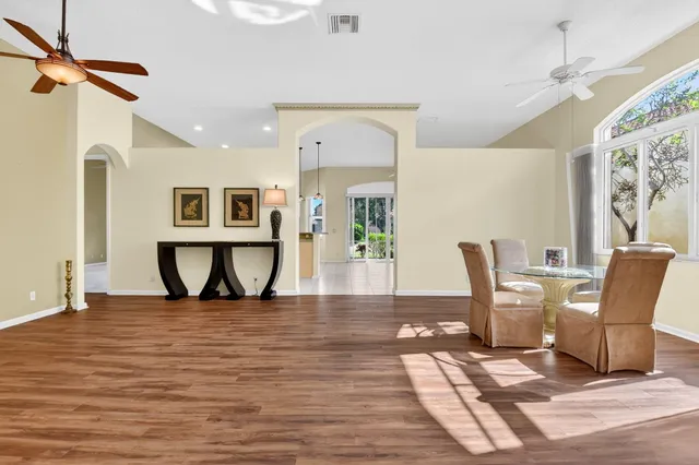 a dining room with wooden floor a glass table and chairs