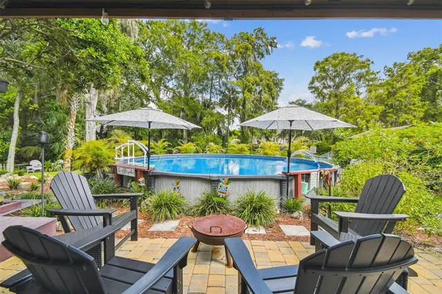 a view of a patio with table and chairs under an umbrella with wooden fence