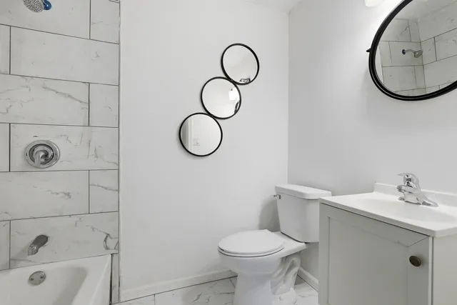 a bathroom with a sink mirror and toilet