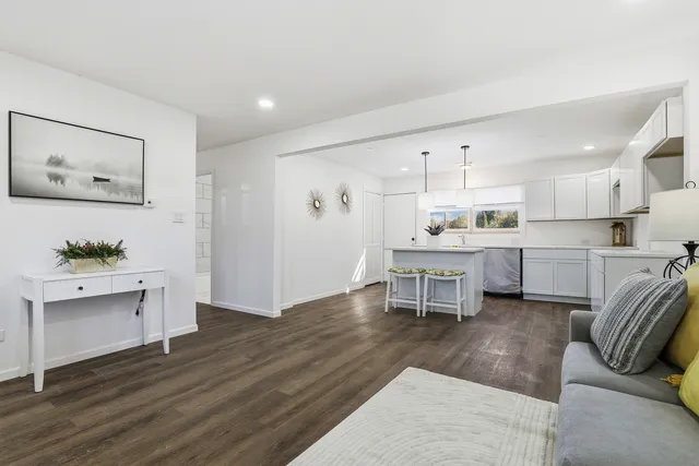 a living room with furniture and a kitchen view